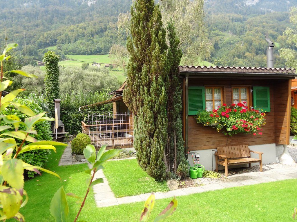 Holzhaus mit Blumenbeet und Garten auf dem Camp